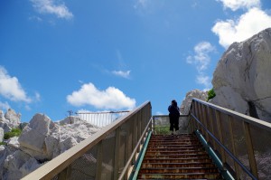 白崎海洋公園内の石灰岩の中を展望台に上る中川アナ